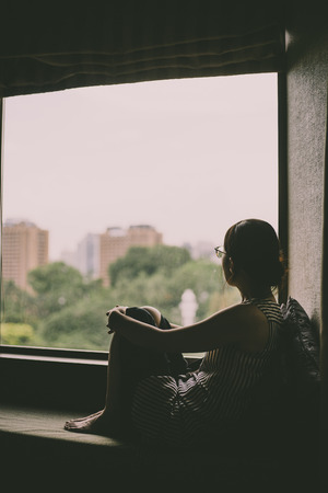 woman looking at a windowの写真素材