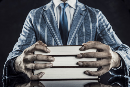 Heavy books and businessmenの写真素材