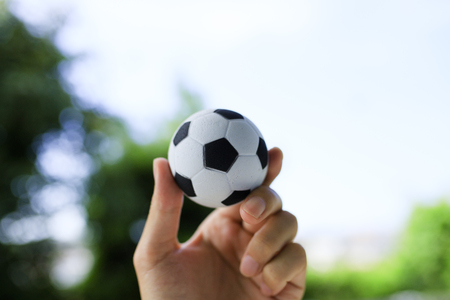 Hand holding a soccer ballの写真素材
