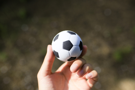 Hand holding a soccer ballの写真素材