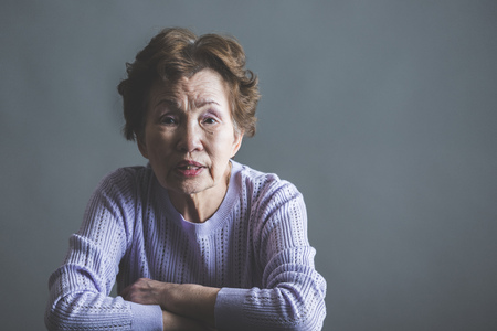 Asian senior woman serious face in studioの写真素材