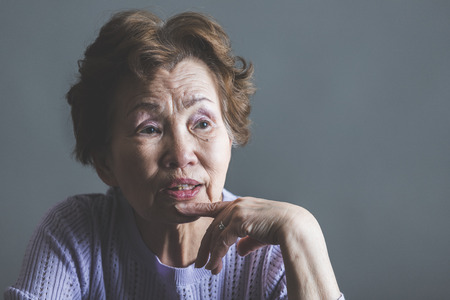 Asian senior woman serious face in studioの写真素材