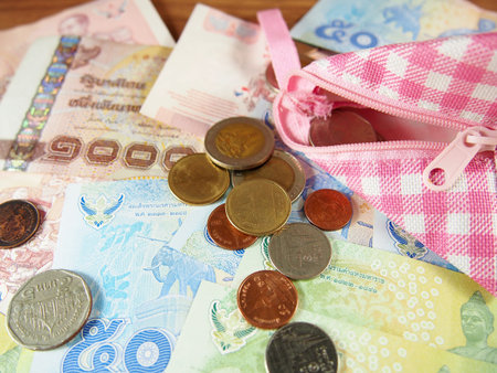 Coins and Banknotes of Thai Baht Money Background with Pink and White Purseの写真素材