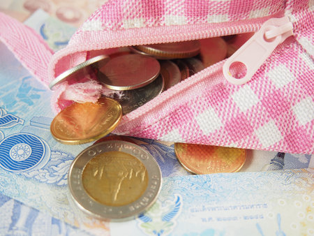 Coins in Purse on Banknotes of Thai Baht Money Backgroundの写真素材