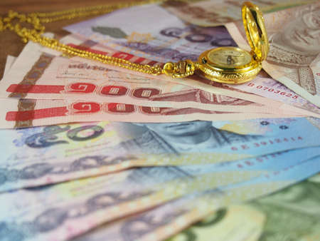 Valuable time with money, banknotes and gold watch with necklaceの写真素材
