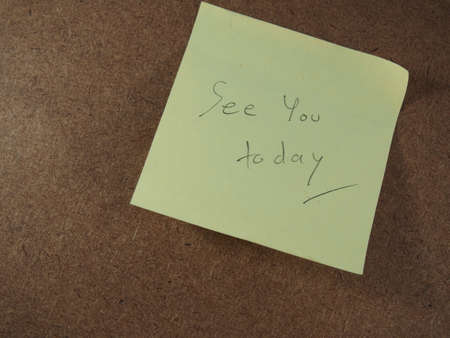 Appointment, see you today, writing on yellow sticker paper, announced brown board backgroundの写真素材