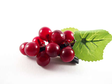 Purple plastic grape fruit shape on black hairpin, decorated with artificial green leafs, hair accessory, isolated on white backgroundの写真素材