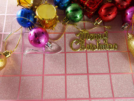 Christmas background on pink tartan with colorful ornamentsの写真素材