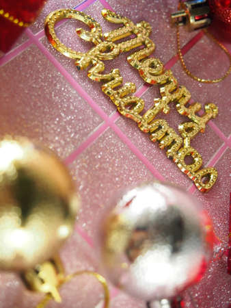 Golden Merry Christmas tag on pink tartan backgroundの写真素材