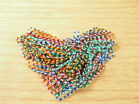 Place colorful paper clips, heart shape on wood backgroundの写真素材