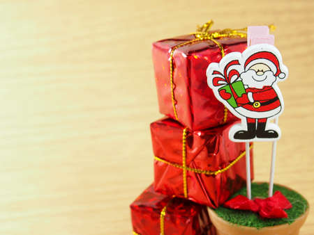 Red  wooden Santa Claus, decorated on handmade paper clip with red gift boxの写真素材
