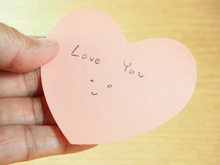 Holding pink paper, heart shape with writing ''love you'' word, Valentines dayの写真素材