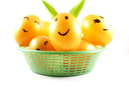 Plastic easter eggs on green basket, decorated light green rabbit ears with happy face with smiling, isolated on white backgroundの写真素材