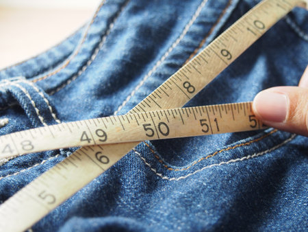 Holding tapeline on waist of jeansの写真素材