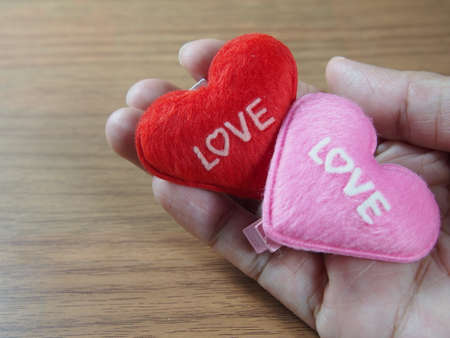 Love word on red and pink little pillows, handmade paper clips in handの写真素材