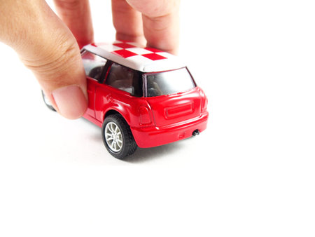 Playing a red car toy, isolated on white backgroundの写真素材