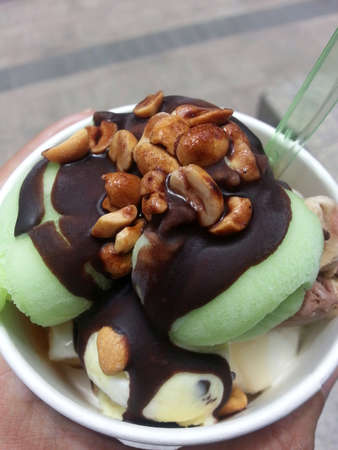 Peanuts topping with chocolate sauce on green ice cream, lemon flavorの写真素材