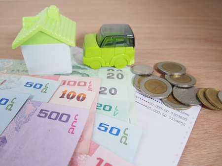 Saving money for car and house concept, account, banknotes, coins, on wooden backgroundの写真素材