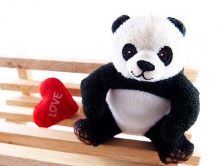 Panda doll on the handmade wooden chair, feeling fall in love conceptの写真素材