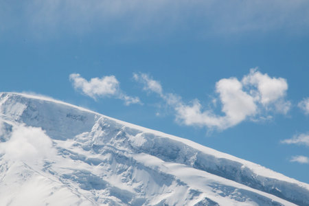 Top of a snow mountain with a cloudy blue sky in xinjiang china