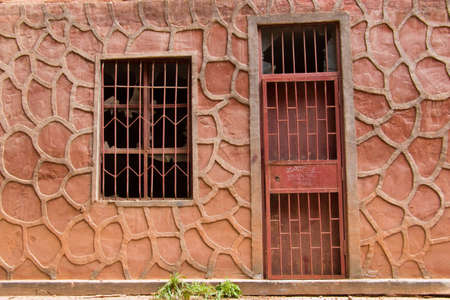 Abandoned house with broken window and bars in front of the doorのeditorial素材