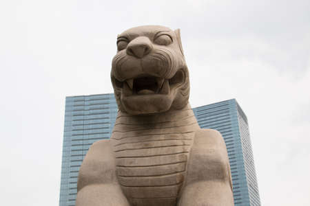 Fierce stone dragon in front of high buildingsのeditorial素材