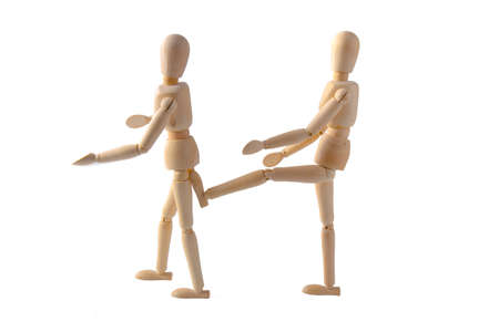 One puppet kicks another puppet on white backgroundの写真素材