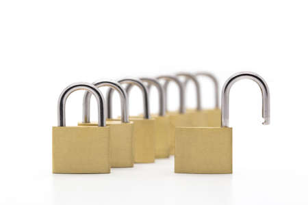 Row of padlocks on white background with one lock openedの写真素材