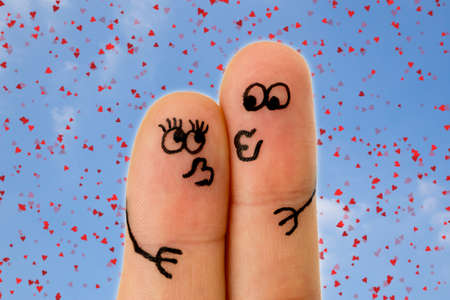 Fingers kissing with faces drawn on themの写真素材