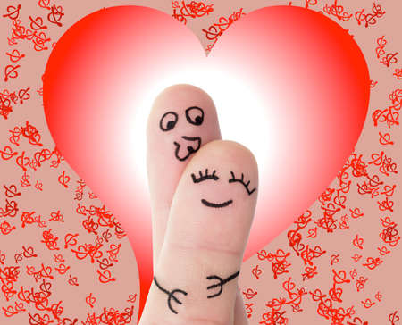 Fingers hugging and kissing with faces drawn on themの写真素材
