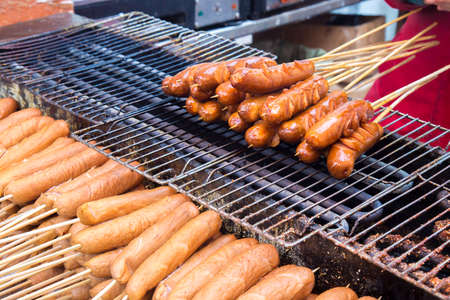 Several Harbin red sausage on sticks being barbecuedの写真素材