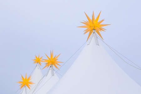 Yellow stars on top of tent on a cloudy dayの写真素材