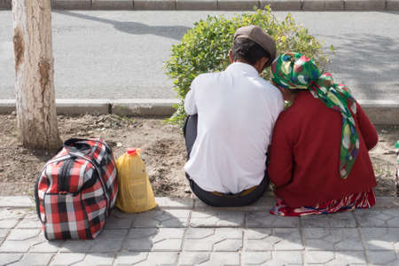 Poor chinese couple sitting at the roadside waiting to be picked upのeditorial素材