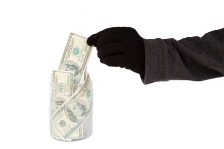 Hand with black glove stealing money from the cookie jarの写真素材