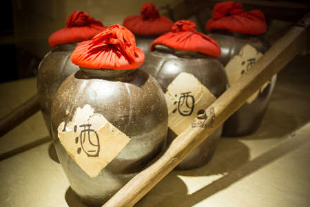 Row of ancient chinese jugs inside with the chinese character for alcohol written on the outsideの写真素材