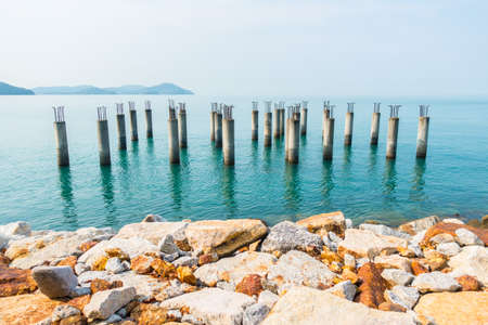 Concrete piles with iron from an unfinished building in the blue waters around Langkawi island Malaysiaの写真素材