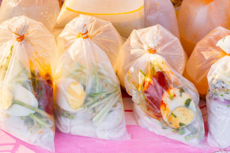 Malaysian style take away noodle dish in transparent plastic bag on a local marketの写真素材