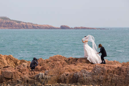 Wedding photography at the coast of Qingdao with a bride being prepared and photographedのeditorial素材