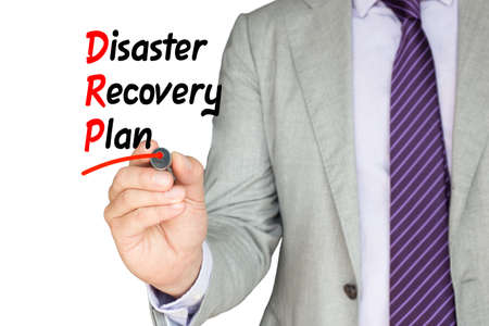 Businessman with a purple tie underlining disaster recovery plan with a red pen on whiteの写真素材