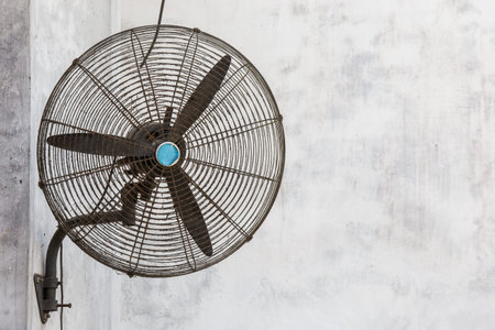 Rusty and dirty old fan on a concrete wall