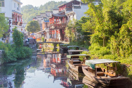 Likeng,China - River leading into the old town of Likeng with old boats and traditional building decorated with red lanternsのeditorial素材
