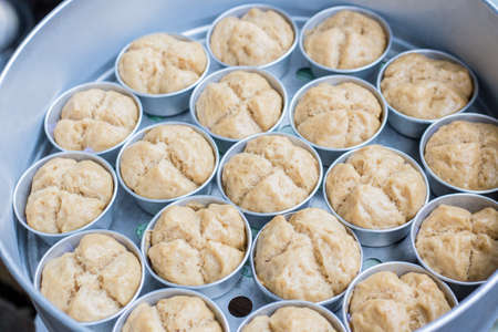 Little muffin shaped steamed muffins in a large bowl on a thai marketの写真素材