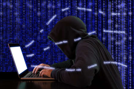 Hacker extracts private information from a notebook in front of a digital background cybersecurity conceptの写真素材