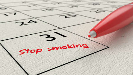 Red ballpen on a paper calendar closeup with the words stop smoking in red 3D illustrationの写真素材