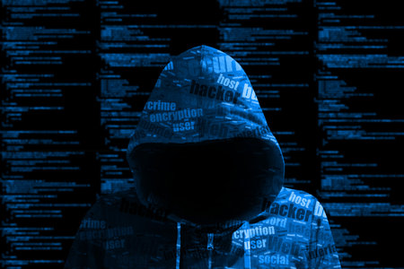 Hacker in a blue hoody standing in front of a code background with binary streams and information...