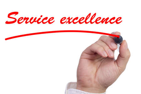 Hand underlining the words service excellence in red isolated on whiteの写真素材
