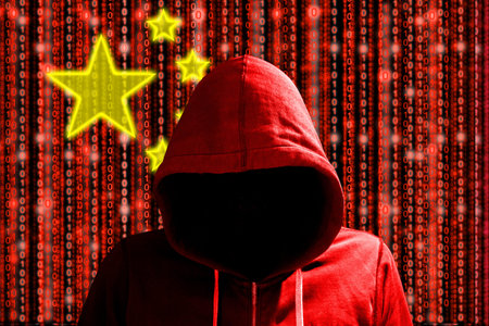 Hacker in a dark red hoody in front of a digital chinese flag and binary streams background...