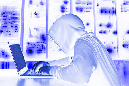 Hooded hacker in a server room analyzing data bright cybersecurity concept