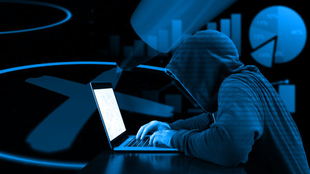 Hacker with blue hoddy typing on a laoptop in front of a ballot paper and charts election...