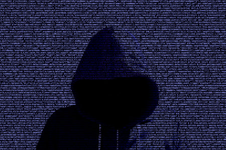 Computer code background with a hooded hacker shining through cybersecurity concept
